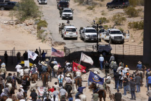 Protesters gather at the Bureau of Land Management's base camp, where cattle that were seized from rancher Cliven Bundy are being held, near Bunkerville, Nevada April 12, 2014. The U.S. Bureau of Land Management on Saturday said it had called off an effort to round up Bundy's herd of cattle that it had said were being illegally grazed in southern Nevada, citing concerns about safety. The conflict between Bundy and U.S. land managers had brought a team of armed federal rangers to Nevada to seize the 1,000 head of cattle. REUTERS/Jim Urquhart (UNITED STATES - Tags: ANIMALS CIVIL UNREST AGRICULTURE CRIME LAW) - RTR3L00X